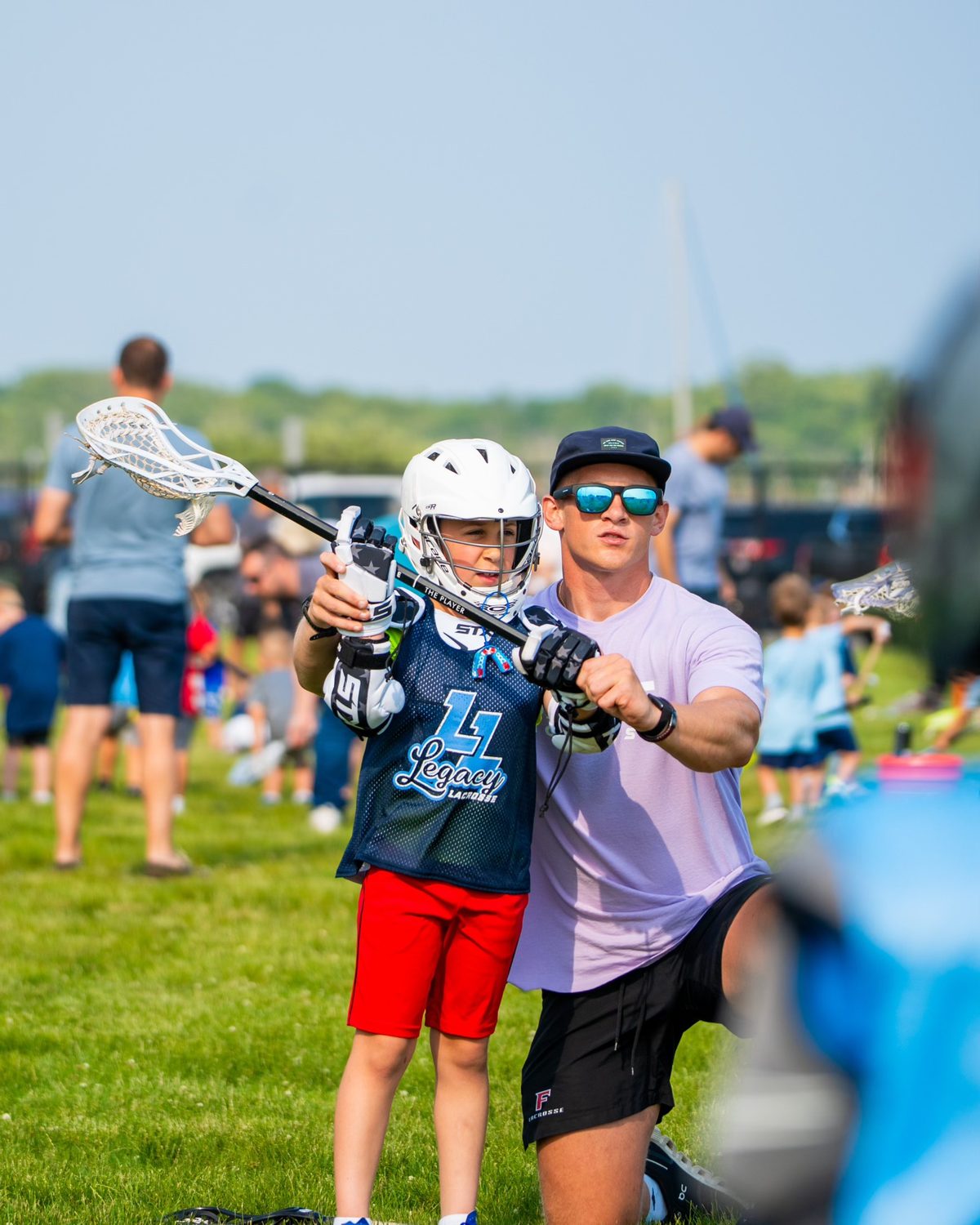 Coach working with a young player at a lacrosse event
